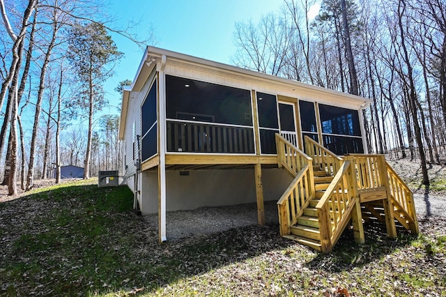 back of property with central AC unit, stairs, and a sunroom