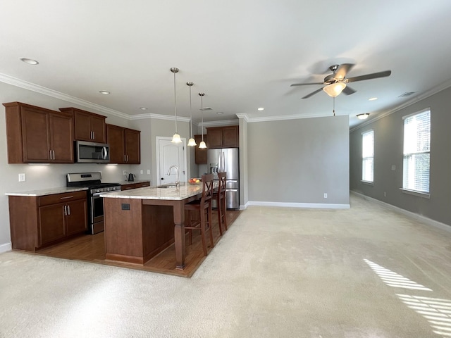 kitchen featuring a kitchen breakfast bar, appliances with stainless steel finishes, crown molding, baseboards, and ceiling fan