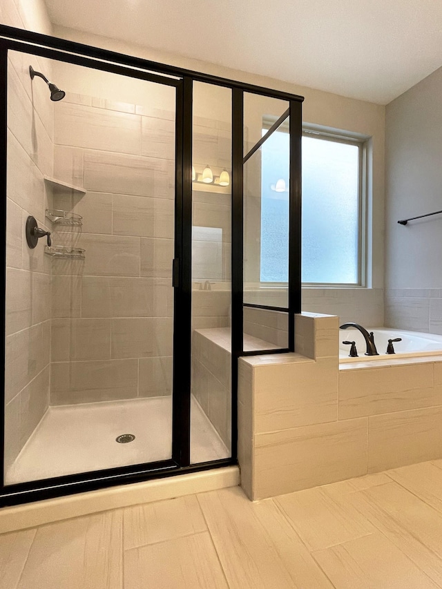 full bathroom with tile patterned floors, a garden tub, and a shower stall