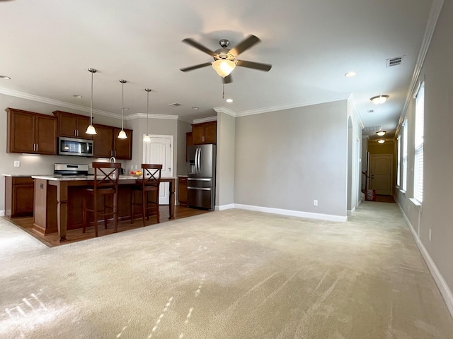 kitchen featuring a kitchen bar, stainless steel appliances, light countertops, baseboards, and light colored carpet