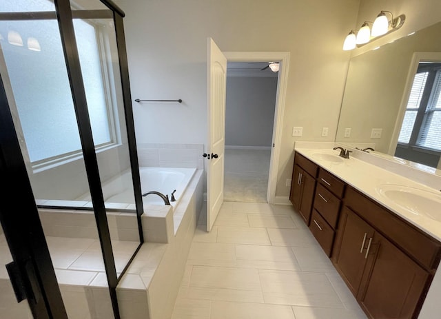 bathroom with a garden tub, double vanity, a stall shower, and a sink