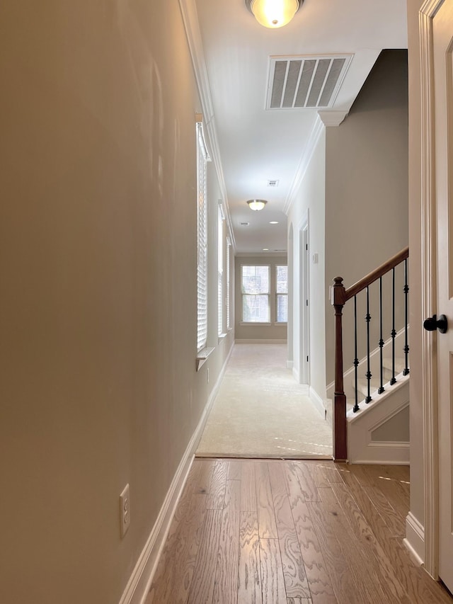 corridor featuring stairs, visible vents, wood finished floors, and crown molding