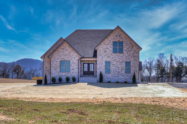 french country inspired facade with brick siding and roof with shingles