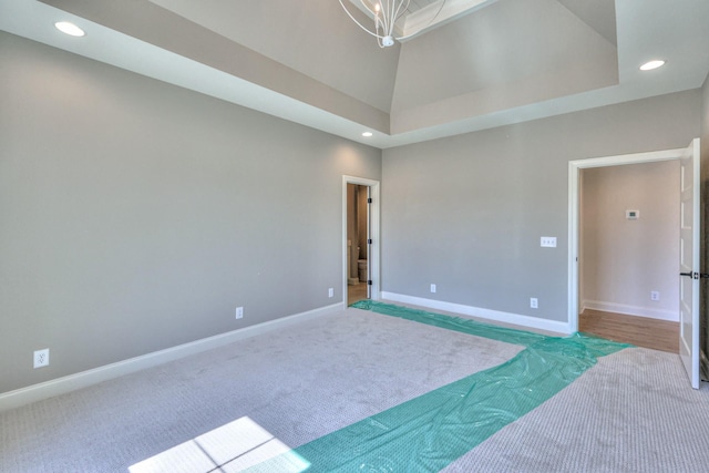 unfurnished room with a notable chandelier, recessed lighting, carpet floors, baseboards, and vaulted ceiling