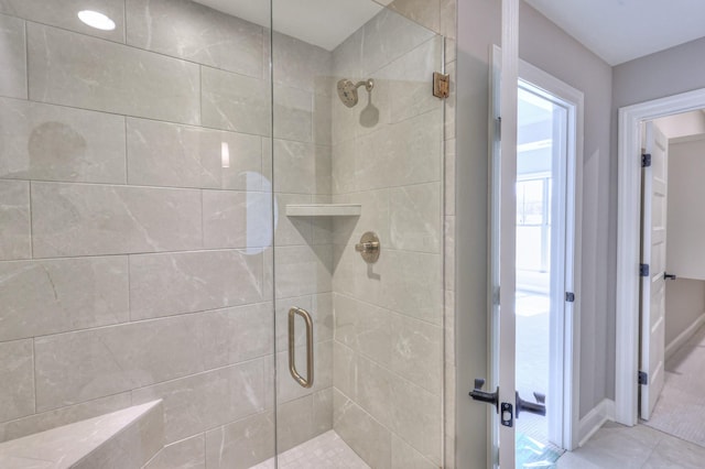 bathroom with a stall shower and tile patterned flooring