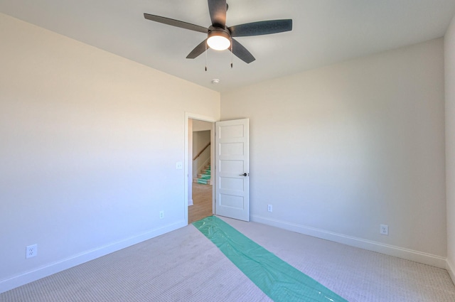 unfurnished bedroom with ceiling fan, baseboards, and light carpet