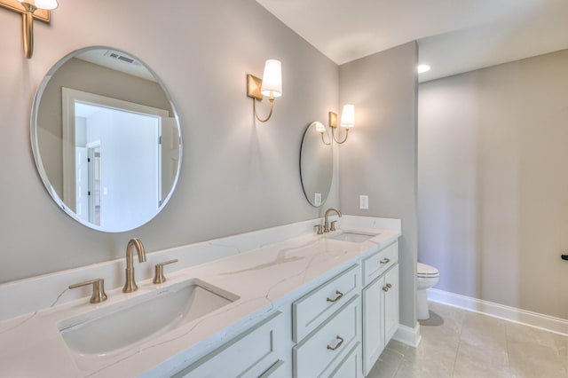 bathroom featuring tile patterned floors, toilet, baseboards, and a sink