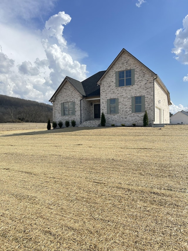 view of front of property featuring brick siding and a front lawn