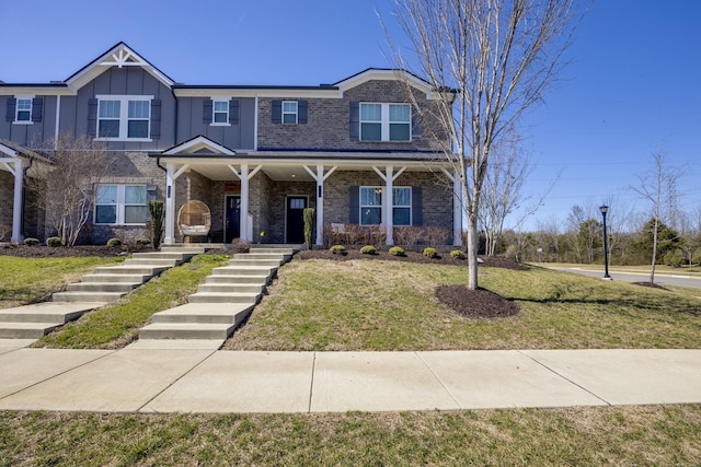 view of front of home featuring brick siding, board and batten siding, covered porch, and a front lawn