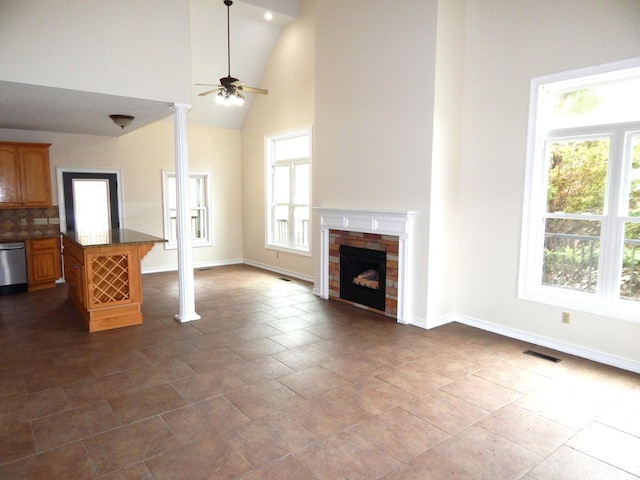 unfurnished living room featuring visible vents, baseboards, high vaulted ceiling, and a fireplace