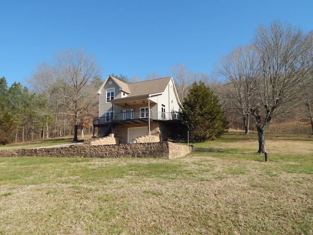 view of side of home with stairway, a lawn, an attached garage, and a wooden deck