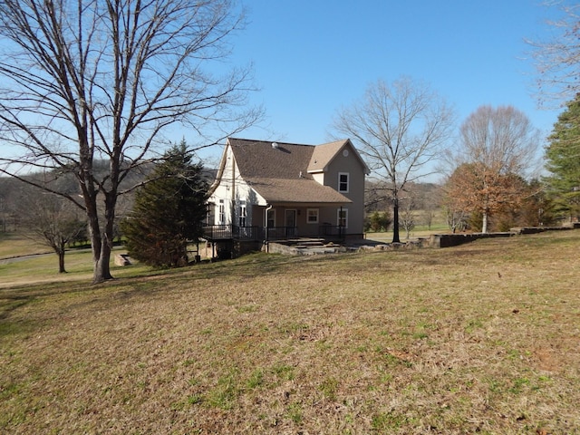 view of side of home with a deck and a yard