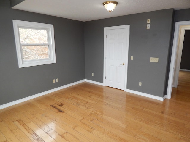 spare room with light wood-style flooring and baseboards