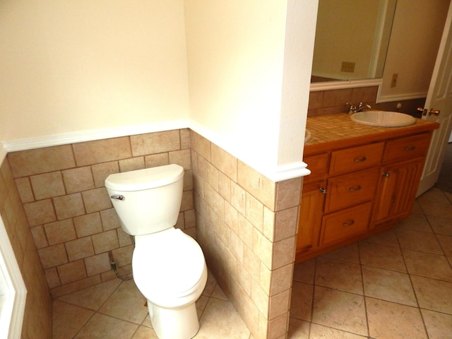 bathroom featuring vanity, tile patterned floors, toilet, and wainscoting