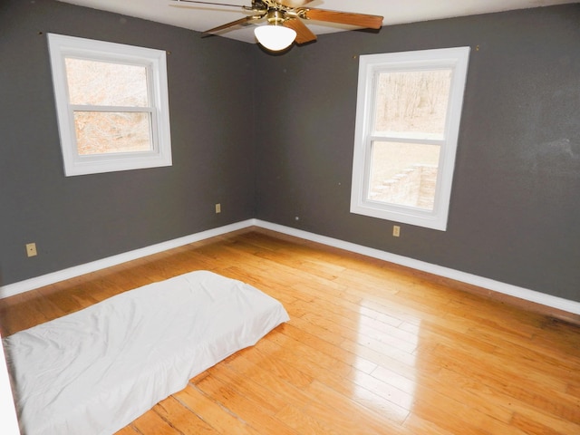 bedroom with a ceiling fan, baseboards, and wood-type flooring