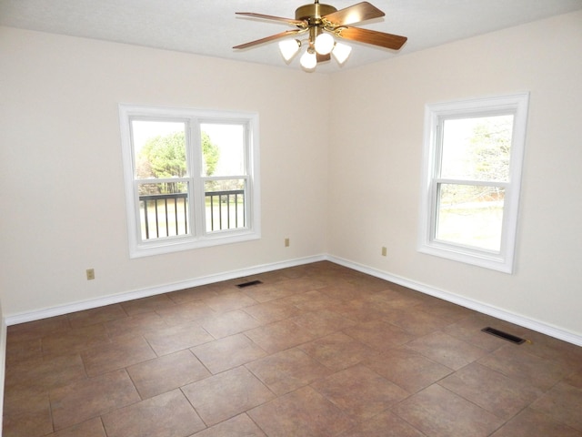 unfurnished room featuring visible vents, baseboards, and ceiling fan