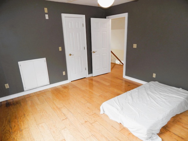 bedroom with baseboards and wood finished floors