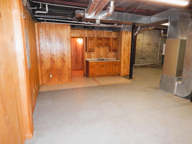 unfinished basement featuring wooden walls, heating unit, and a sink