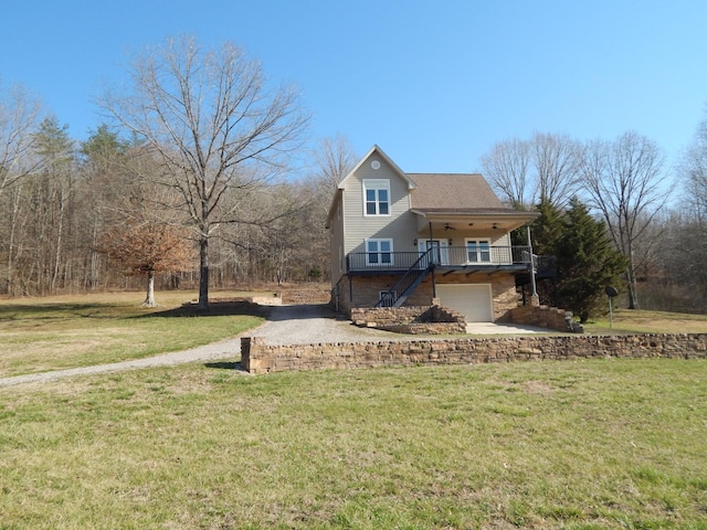 view of front of house with stairs, a front yard, an attached garage, and a ceiling fan