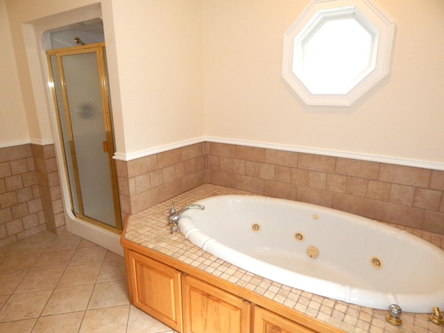 full bath with tile patterned flooring, a shower stall, a jetted tub, and tile walls