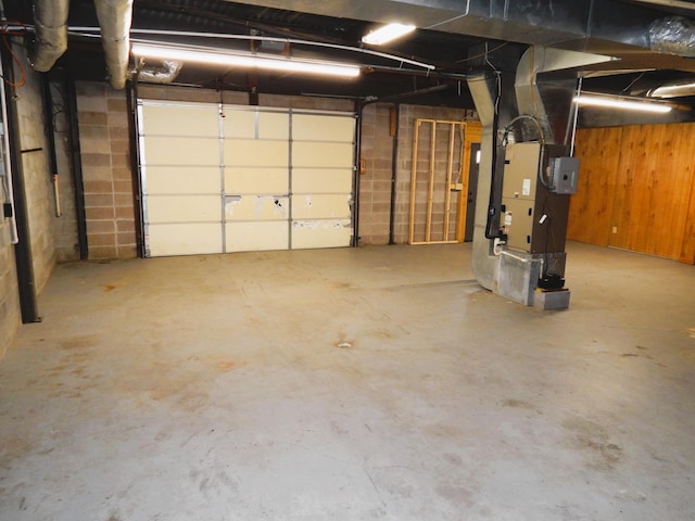 garage featuring heating unit and concrete block wall