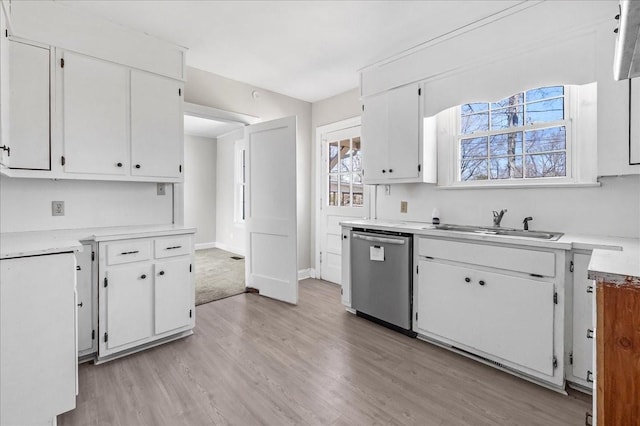 kitchen with dishwasher, white cabinetry, and a sink