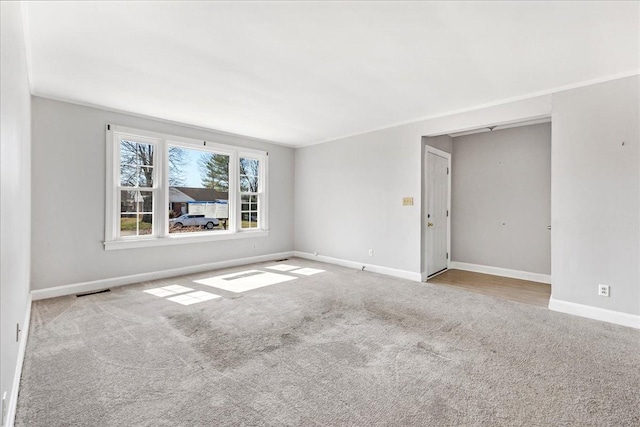 spare room with visible vents, baseboards, and carpet