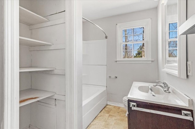 bathroom with baseboards, toilet, bathtub / shower combination, and vanity