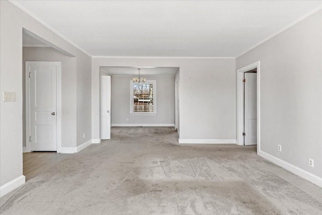 carpeted spare room featuring baseboards and an inviting chandelier