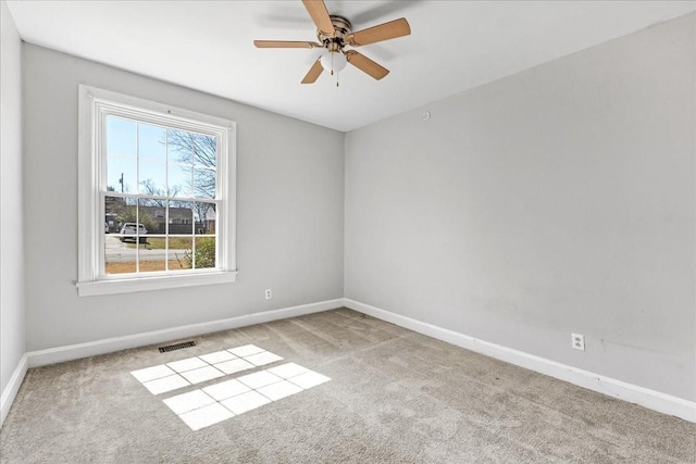 carpeted empty room featuring visible vents, baseboards, and ceiling fan