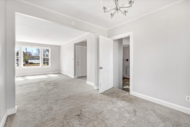 carpeted empty room with baseboards, a notable chandelier, and ornamental molding