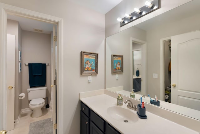 bathroom featuring vanity, toilet, baseboards, and tile patterned flooring