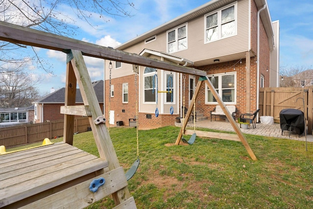 back of property featuring a wooden deck, a yard, a fenced backyard, a patio area, and brick siding