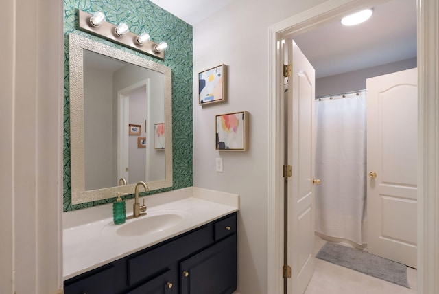 bathroom featuring vanity and wallpapered walls