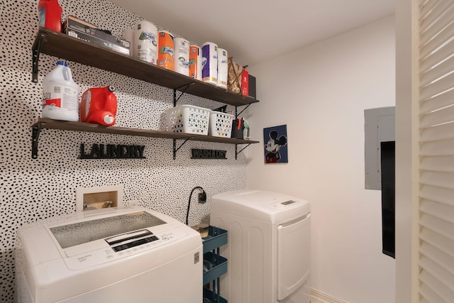 clothes washing area featuring washer and dryer, laundry area, electric panel, and baseboards