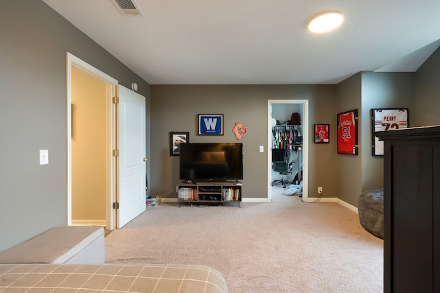 carpeted bedroom featuring a closet, visible vents, a walk in closet, and baseboards