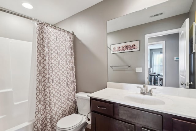 bathroom featuring vanity, shower / bath combo with shower curtain, toilet, and visible vents