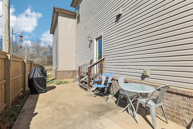 view of patio / terrace with entry steps, outdoor dining area, and fence