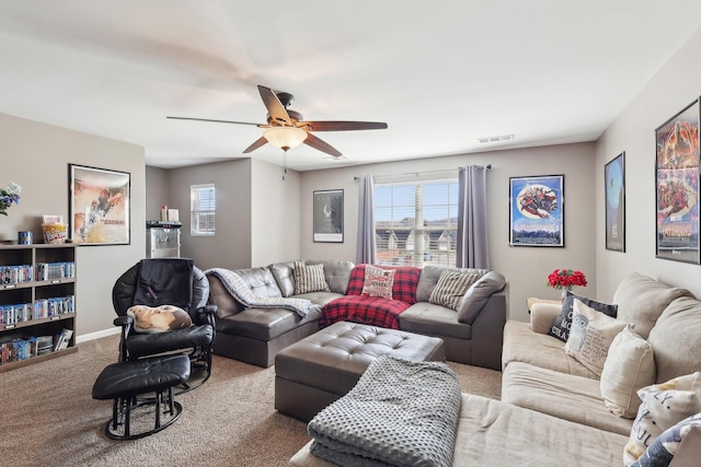 living area with baseboards, visible vents, carpet floors, and ceiling fan