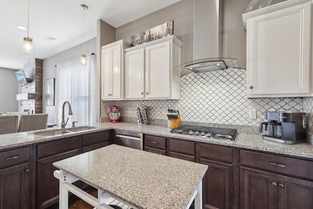 kitchen with backsplash, wall chimney range hood, dark brown cabinetry, stainless steel appliances, and a sink