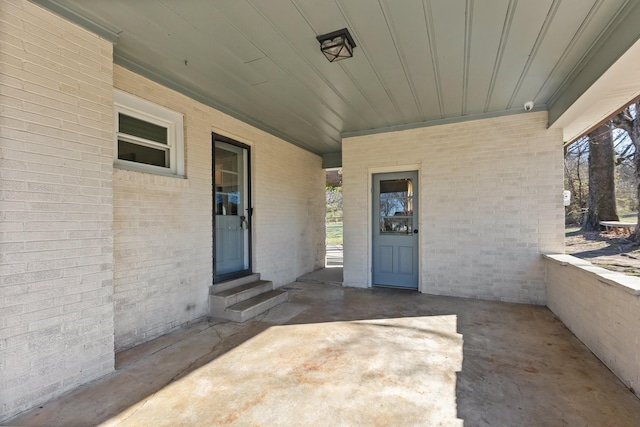 view of exterior entry with brick siding