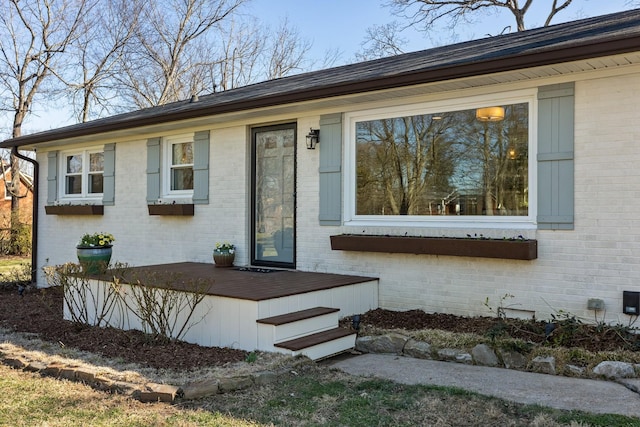 view of front of property featuring brick siding and a deck