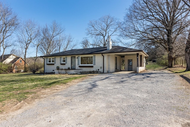 view of front of property featuring an attached carport, gravel driveway, a chimney, a front lawn, and crawl space