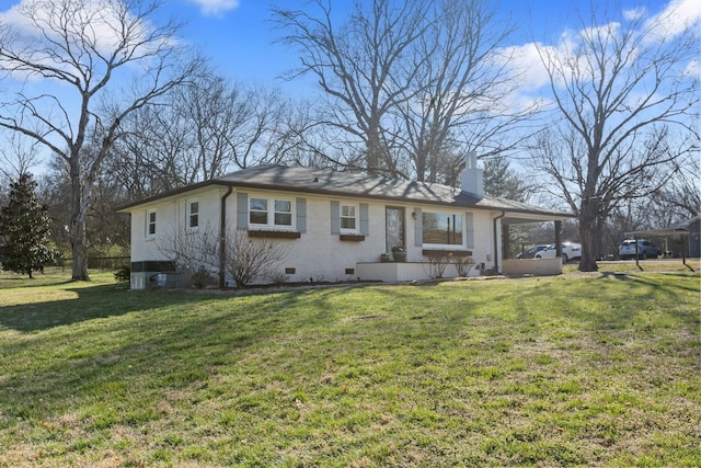 view of front of property with an attached carport, a front yard, crawl space, brick siding, and a chimney