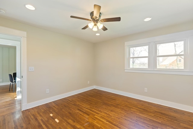 empty room with dark wood finished floors, recessed lighting, baseboards, and ceiling fan