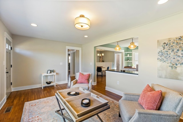 living area with visible vents, a notable chandelier, wood finished floors, recessed lighting, and baseboards