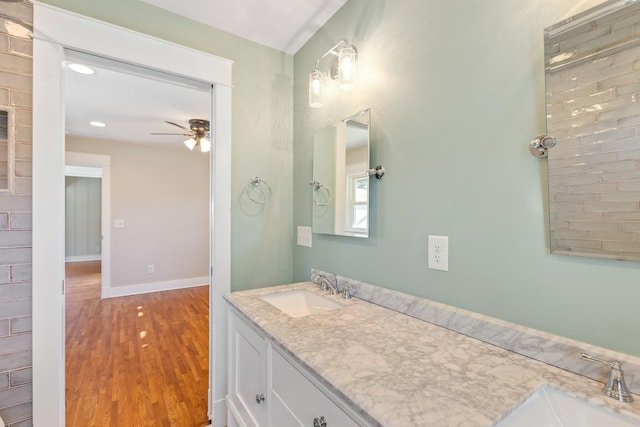 bathroom featuring double vanity, wood finished floors, ceiling fan, and a sink