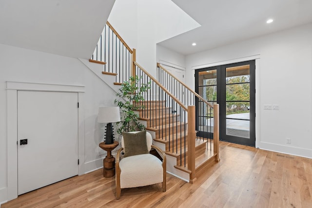 entrance foyer with recessed lighting, french doors, stairway, light wood-style floors, and baseboards