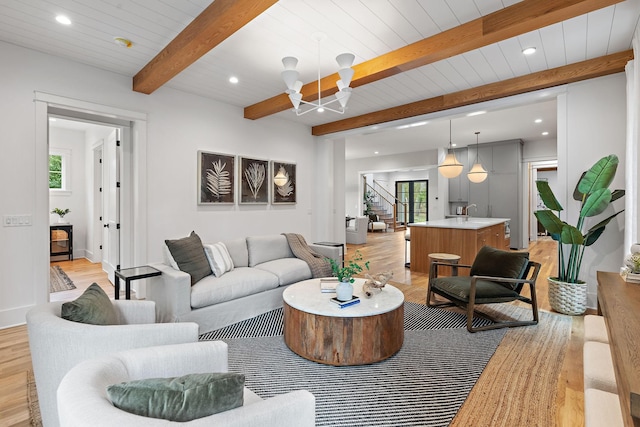 living area with stairs, light wood-style flooring, and a healthy amount of sunlight