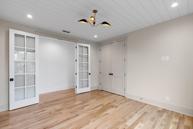 unfurnished room featuring light wood-type flooring, baseboards, wood ceiling, and french doors